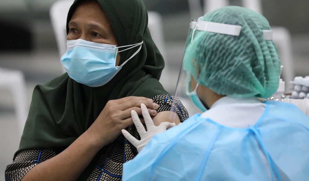 Lady after injected with a vaccine by a nurse in Thailand.